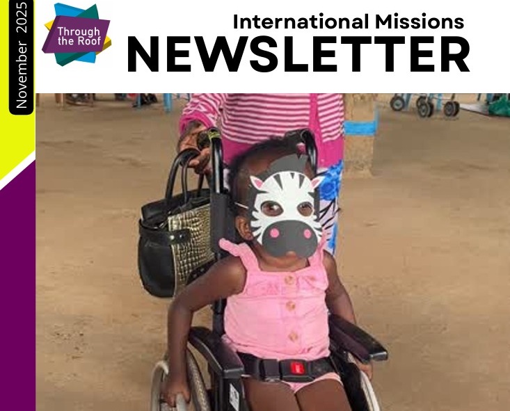 A young child in a wheelchair wearing a zebra mask sits in front of an adult, with the header International Missions Newsletter Nov 2025.