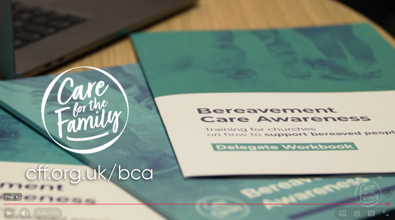 Screen shot from a Care for the Family Bereavement Care video, showing a copy of a Bearvement Care Awareness delegate workbook is displayed on a table. On Screen alongside is the charity's website address: cff.org.uk/bca