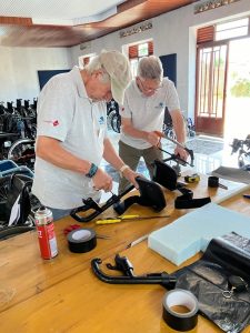 Two male UK volunteer ‘techies’ working with saws to cut up padding for fitting wheelchairs.