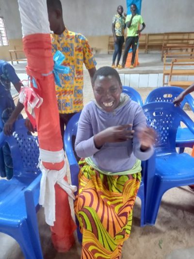 A young disabled girl in a purple jumper sits