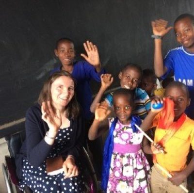 Katie, a TTR team member, sat in her wheelchair with a group of African schoolchildren on a Churches Inclusion trip