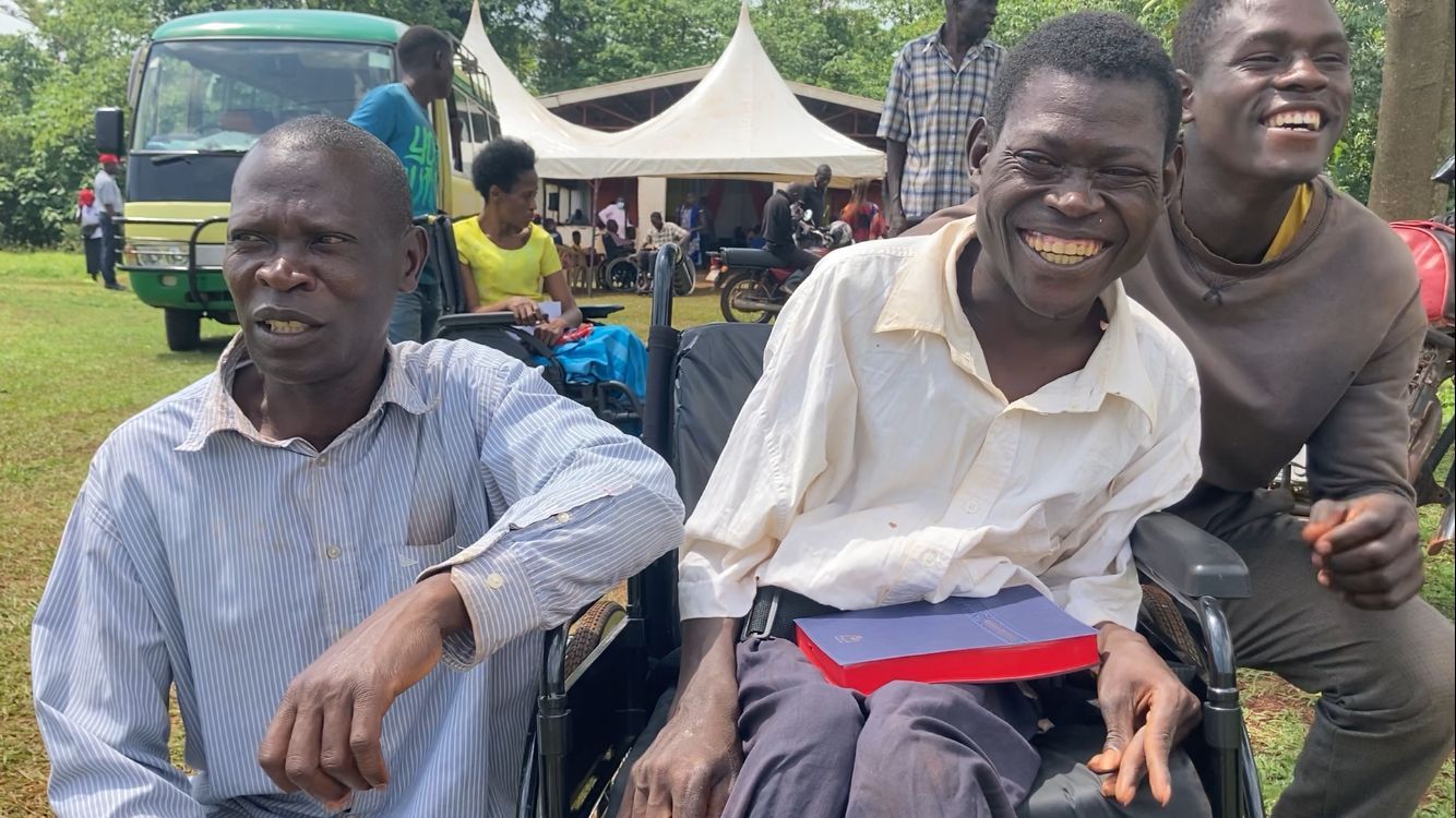 a young man with his new wheelchair, with his brothers on either side of him