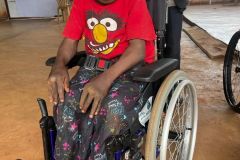A child in a red t shirt in their new wheelchair