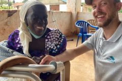 A team member and a mobility aid recipient smiling together after a fitting