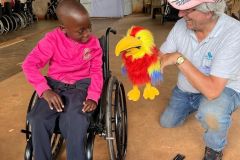 A team member entertains a child with Henry, the bird puppet
