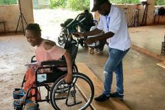 A recipient is pushed along in her new wheelchair