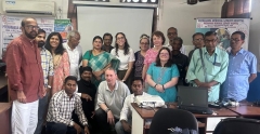 Large group photo of about 20 UK and local Indian volunteers, both men and women, in a classroom