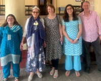 Four smiling UK volunteers - 4 female and 1 male - stood outside a Church in India