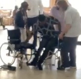 Sylvanus a young man from Ghana transferring into his new wheelchair.