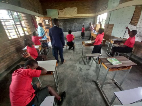 Several students in red jumpers sat around in the school room