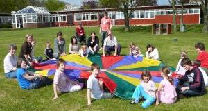 A group on the holiday playing a parachute game