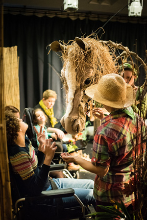 A puppet of a horse interacts with the audience during a show