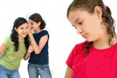 two young girls laughing behind another girls back