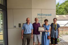 Four members of the team at Guildford Baptist Church standing outside their new more accessible Milmead building, holding their Luke 5 certificate