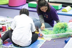 A young person and an older person doing an activity with coloured paper