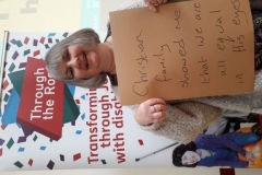 Karen holding a sign saying 'Christian Family taught me we are all equal in his eyes