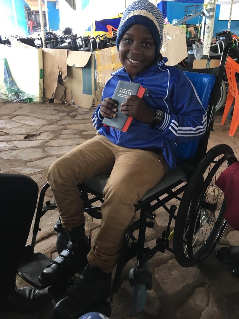 A young boy sat in his new wheelchair holding his new Bible