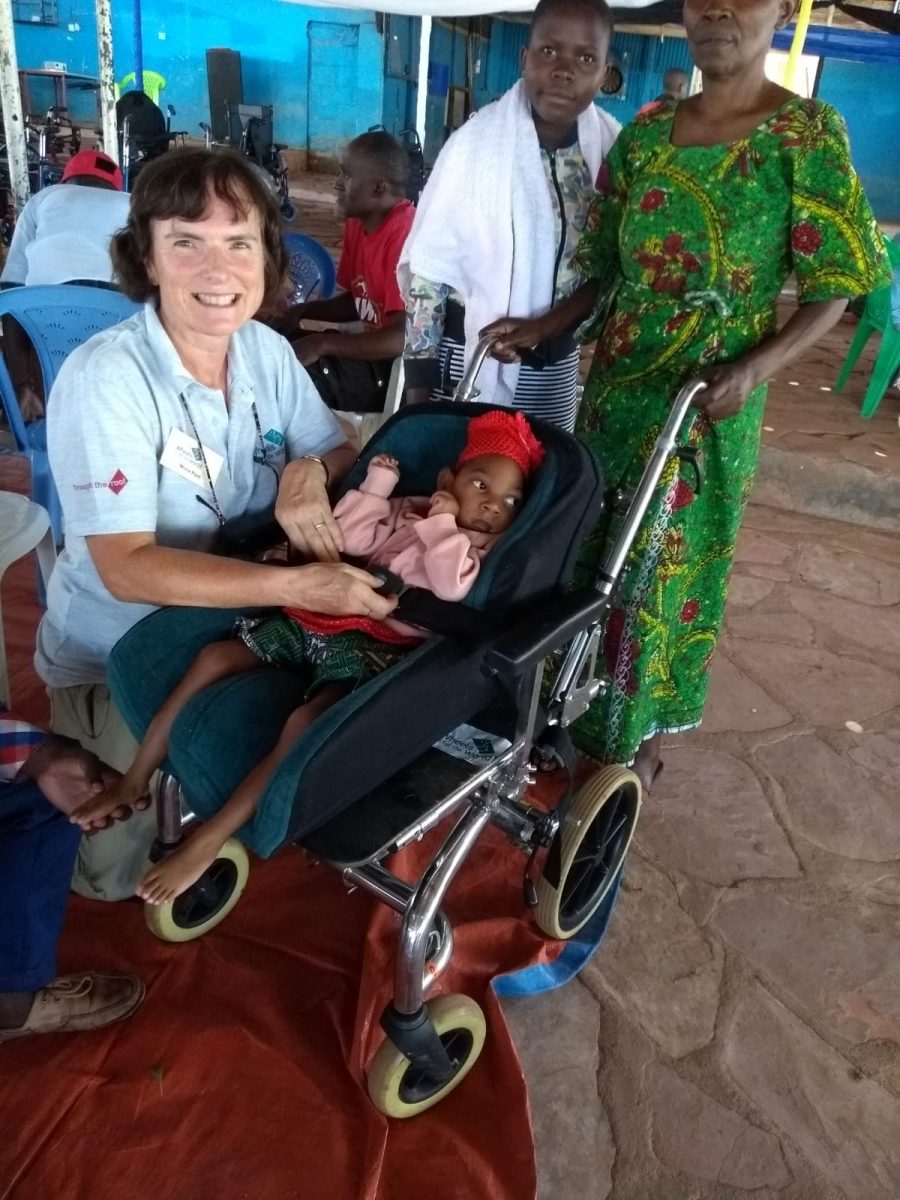 A young girl in her very specialised wheelchair and her family