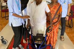 A recipient with their new mobility walker, supported by Indian hospital staff and a family member