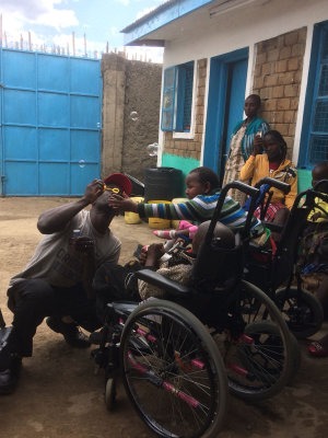 Pastor Michael blows bubbles to entertain the children