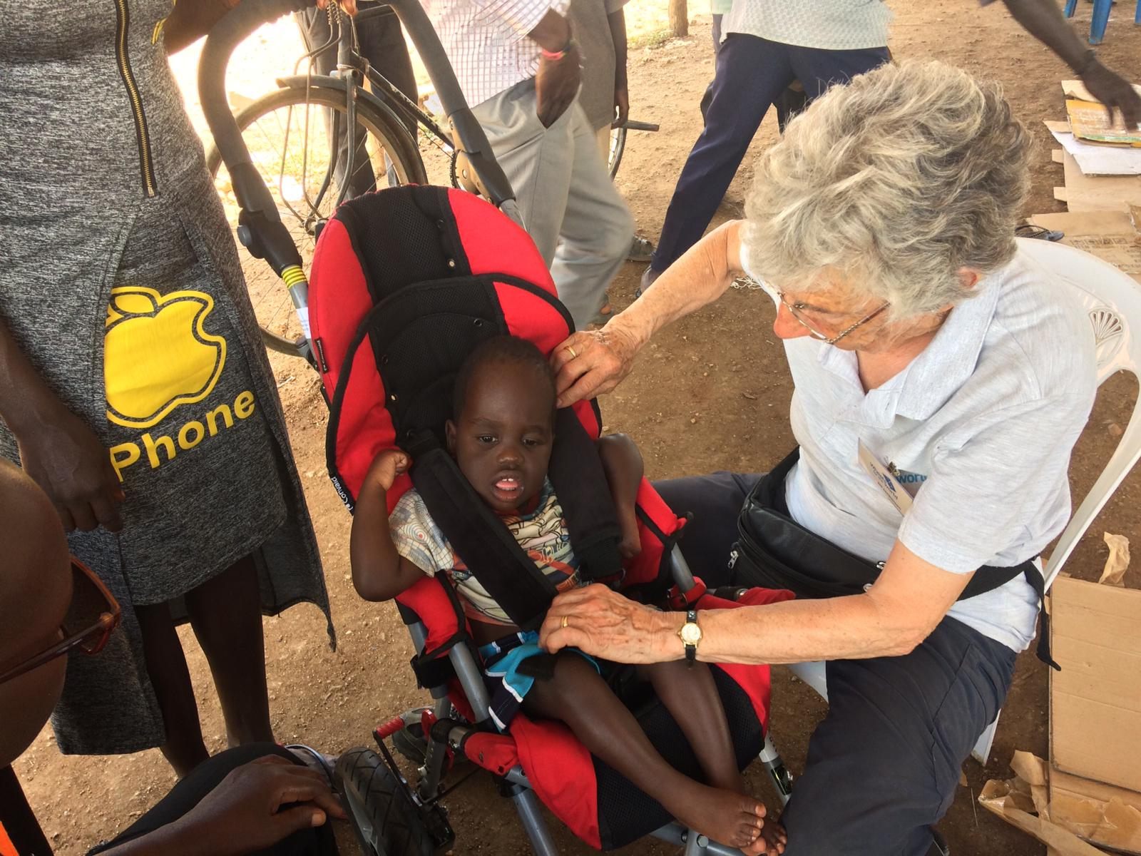 Team leader, Jill, fitting a young child with a specially adapted buggy