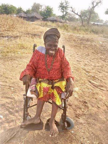 Mariamu smiles while she sits in her new wheelchair