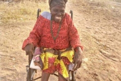 Mariamu smiles while she sits in her new wheelchair