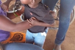 A little girl being helped with a wheelchair fitting