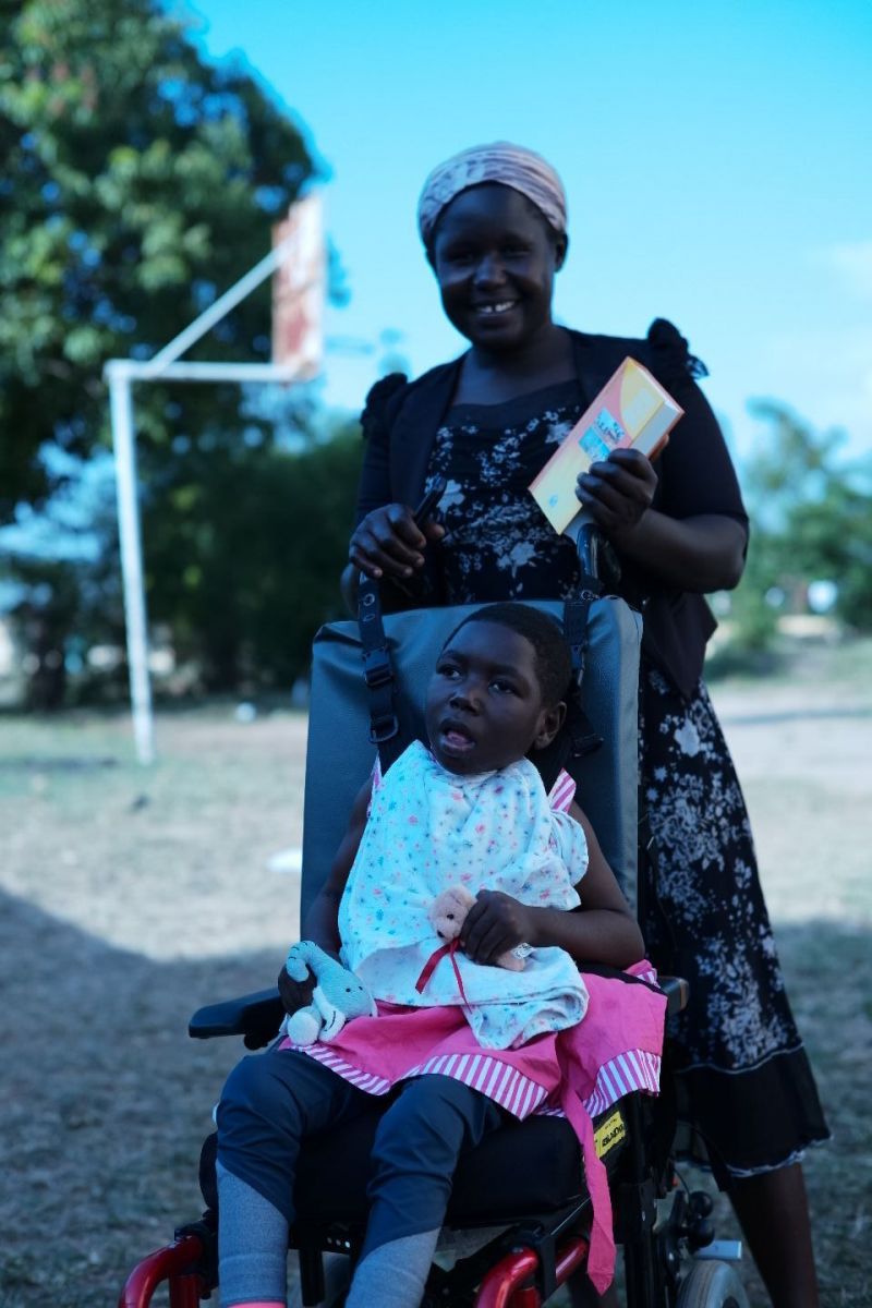 Christine sits in her new chair, with her mother, Elizabeth standing behind her